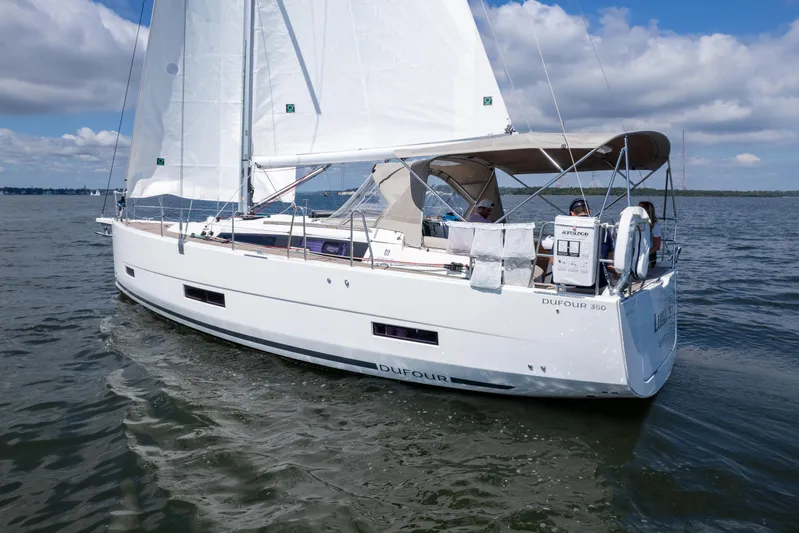 Lunar Sea Yacht Photos Pics 2023 Dufour 390 sailboat cruising on open water under a clear sky.