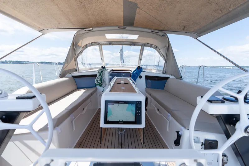 Lunar Sea Yacht Photos Pics 2023 Dufour 390 yacht cockpit with navigation system, spacious seating, and ocean view.