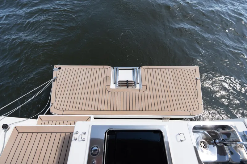 Lunar Sea Yacht Photos Pics 2023 Dufour 390 yacht stern with swim platform and ladder on water.