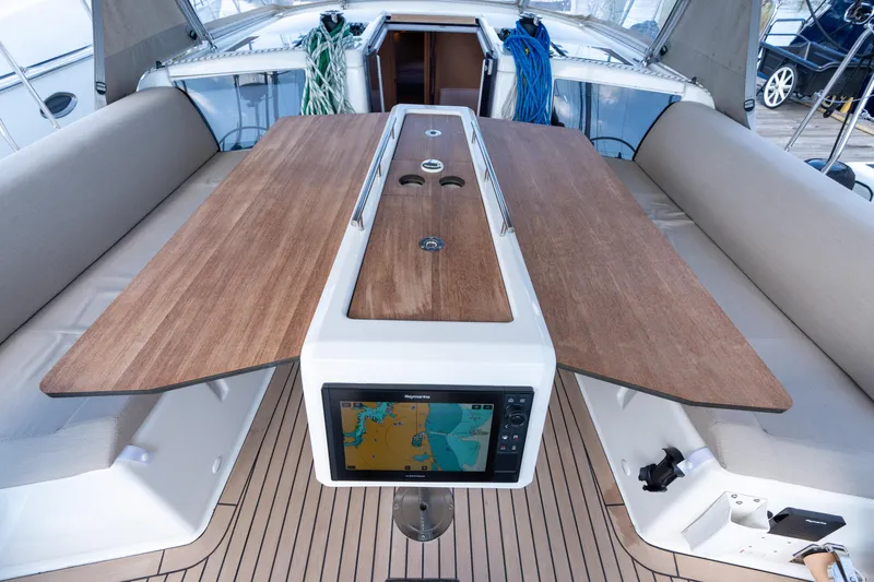 Lunar Sea Yacht Photos Pics 2023 Dufour 390 yacht cockpit with wooden table and navigation display.