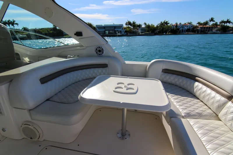 Morena Yacht Photos Pics 2008 Sea Ray 48 Sundancer yacht interior with plush seating and table, overlooking serene water.