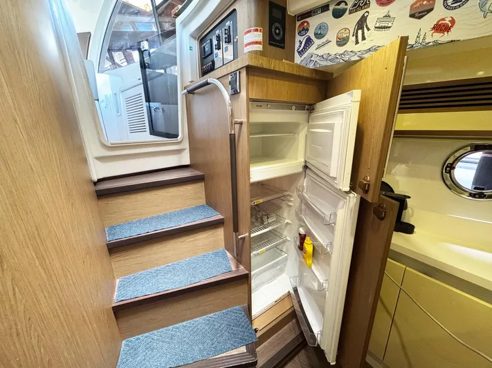 Wanderlust Yacht Photos Pics 2015 Beneteau Gran Turismo 44 interior with open fridge, wooden stairs, and nautical decor.