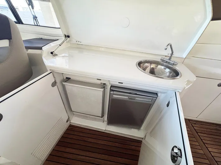 Wanderlust Yacht Photos Pics 2015 Beneteau Gran Turismo 44 yacht kitchenette with sink, mini fridge, and wooden flooring.