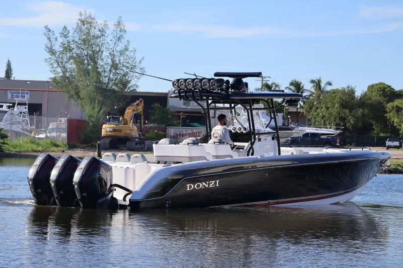  Yacht Photos Pics 2012 Donzi 38 ZF Open boat with multiple outboard engines on a calm waterway.