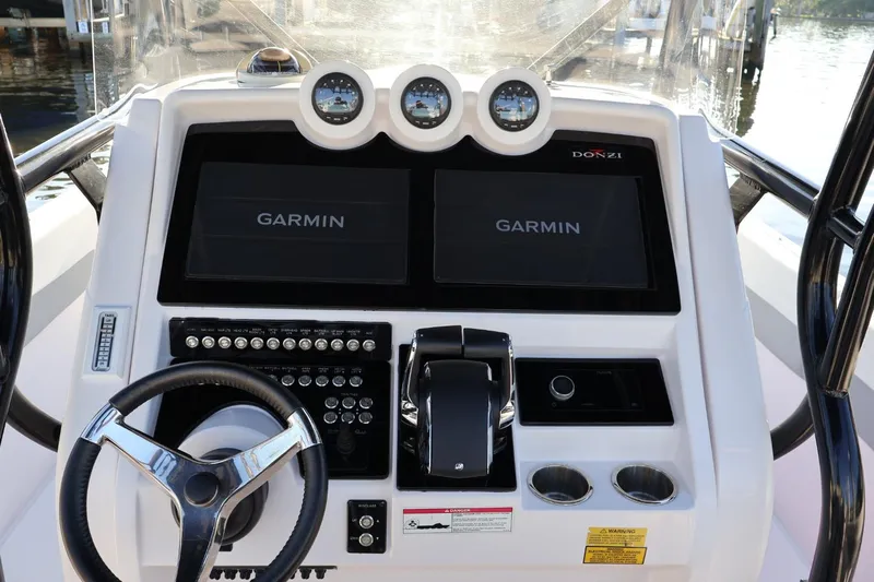  Yacht Photos Pics Control panel of 2012 Donzi 38 ZF Open boat with Garmin displays and steering wheel.