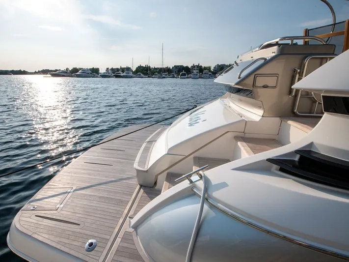 Namari Yacht Photos Pics 2022 Riviera 6000 Sport Yacht Platinum on serene water at sunset.