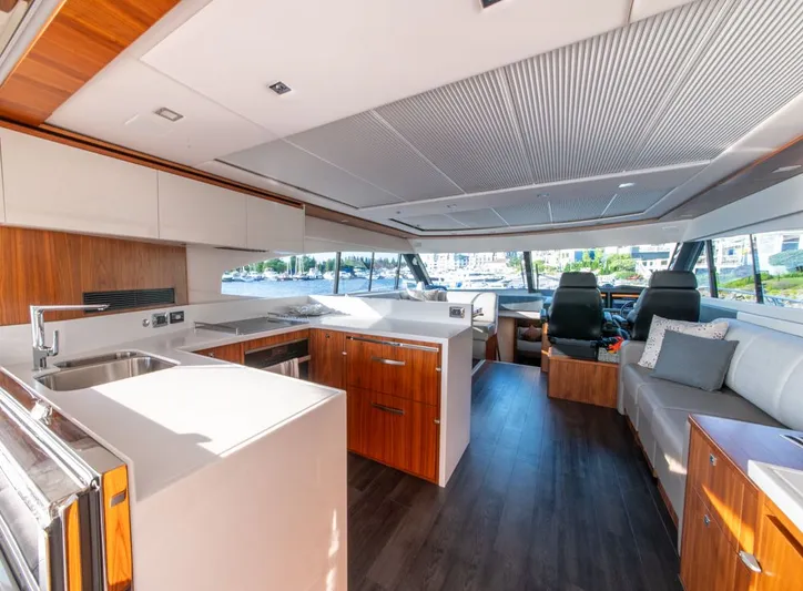 Namari Yacht Photos Pics Luxurious interior of 2022 Riviera 6000 Sport Yacht Platinum with modern kitchen and seating.