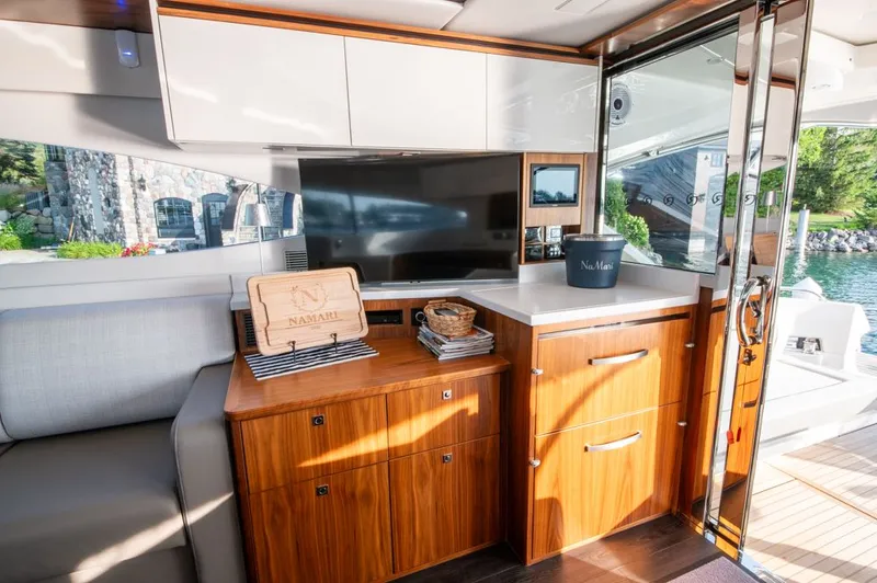 Namari Yacht Photos Pics Luxurious interior of 2022 Riviera 6000 Sport Yacht Platinum with modern cabinetry and scenic view.