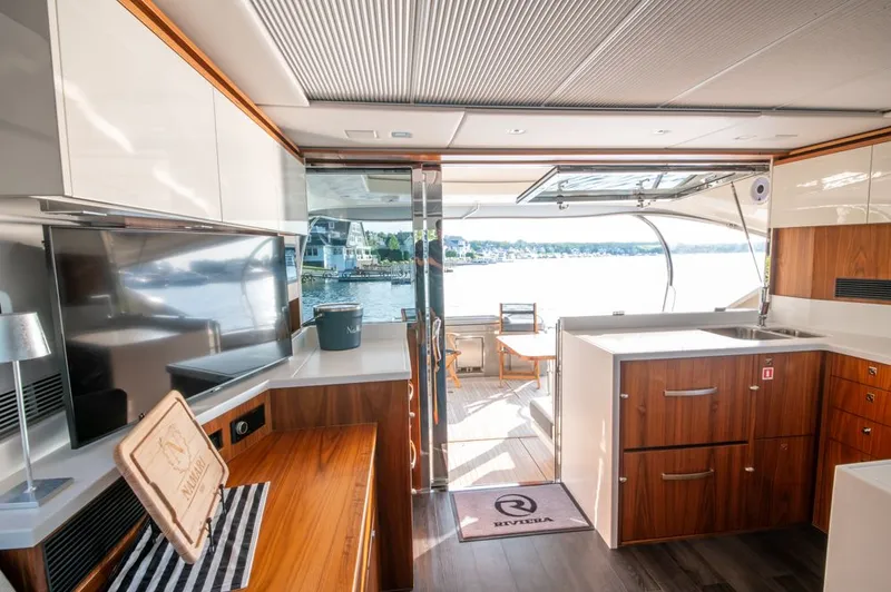 Namari Yacht Photos Pics Luxurious interior of 2022 Riviera 6000 Sport Yacht Platinum with modern kitchen and scenic view.