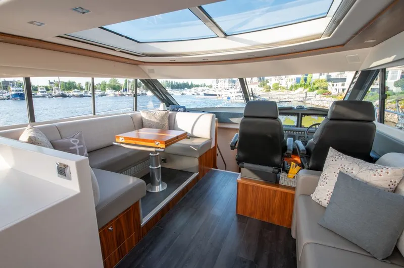 Namari Yacht Photos Pics Luxurious interior of 2022 Riviera 6000 Sport Yacht Platinum with panoramic windows and plush seating.