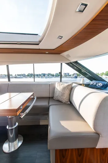 Namari Yacht Photos Pics Luxurious interior of 2022 Riviera 6000 Sport Yacht Platinum with elegant seating and table.