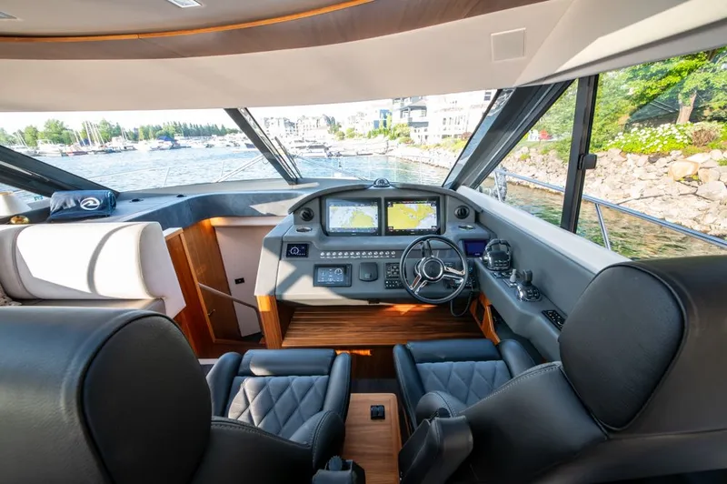 Namari Yacht Photos Pics 2022 Riviera 6000 Sport Yacht Platinum helm with modern navigation displays and luxurious seating.