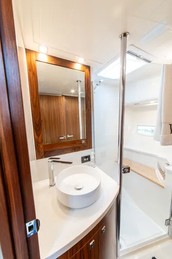 Namari Yacht Photos Pics Luxurious bathroom in 2022 Riviera 6000 Sport Yacht Platinum, featuring modern fixtures and elegant wood accents.
