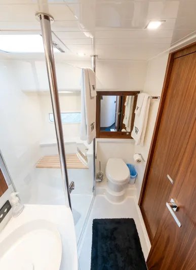 Namari Yacht Photos Pics Luxurious bathroom in 2022 Riviera 6000 Sport Yacht Platinum, featuring modern fixtures and elegant wood accents.