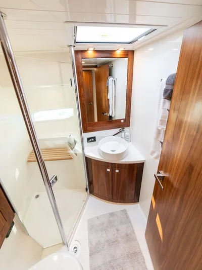 Namari Yacht Photos Pics Luxurious bathroom in 2022 Riviera 6000 Sport Yacht Platinum with wood accents and modern fixtures.