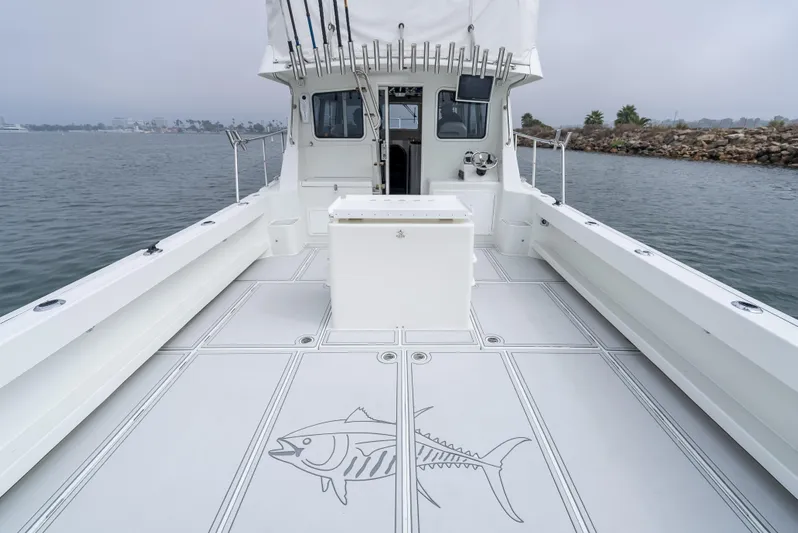  Yacht Photos Pics 2018 Lindell 46 F boat deck with fish design, docked by rocky shoreline.