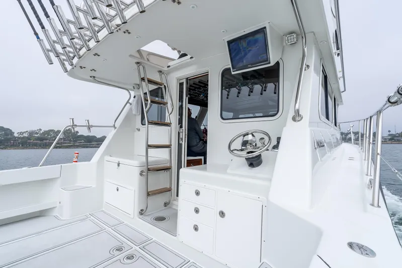  Yacht Photos Pics Lindell 46 F 2018 boat interior with steering wheel and ladder, docked on a cloudy day.