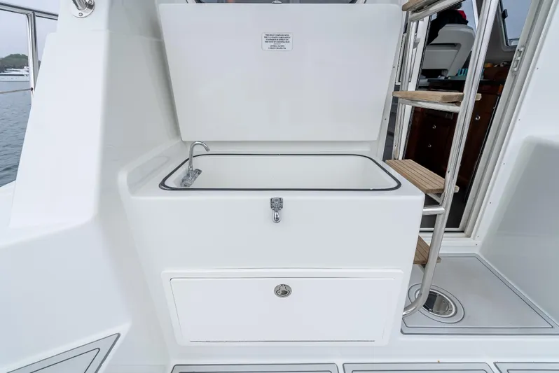  Yacht Photos Pics Lindell 46 F 2018 boat interior with open storage compartment and wooden steps.