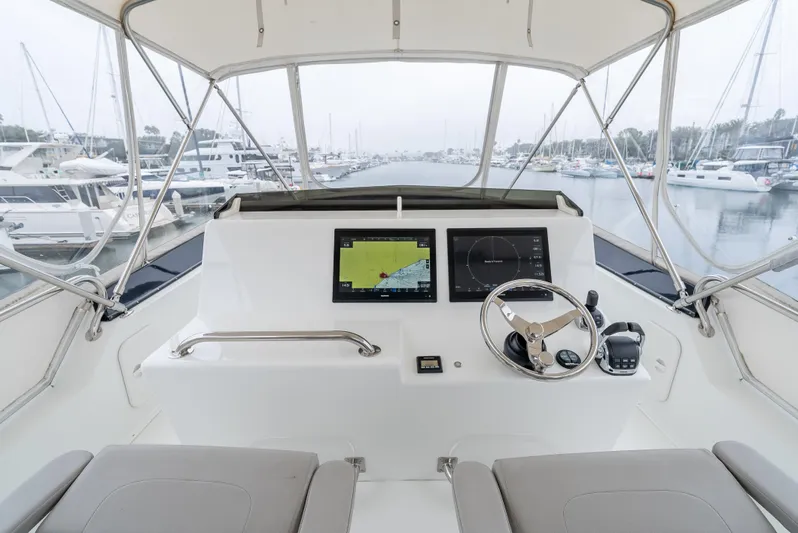  Yacht Photos Pics Lindell 46 F 2018 yacht helm with navigation screens and steering wheel, docked in marina.