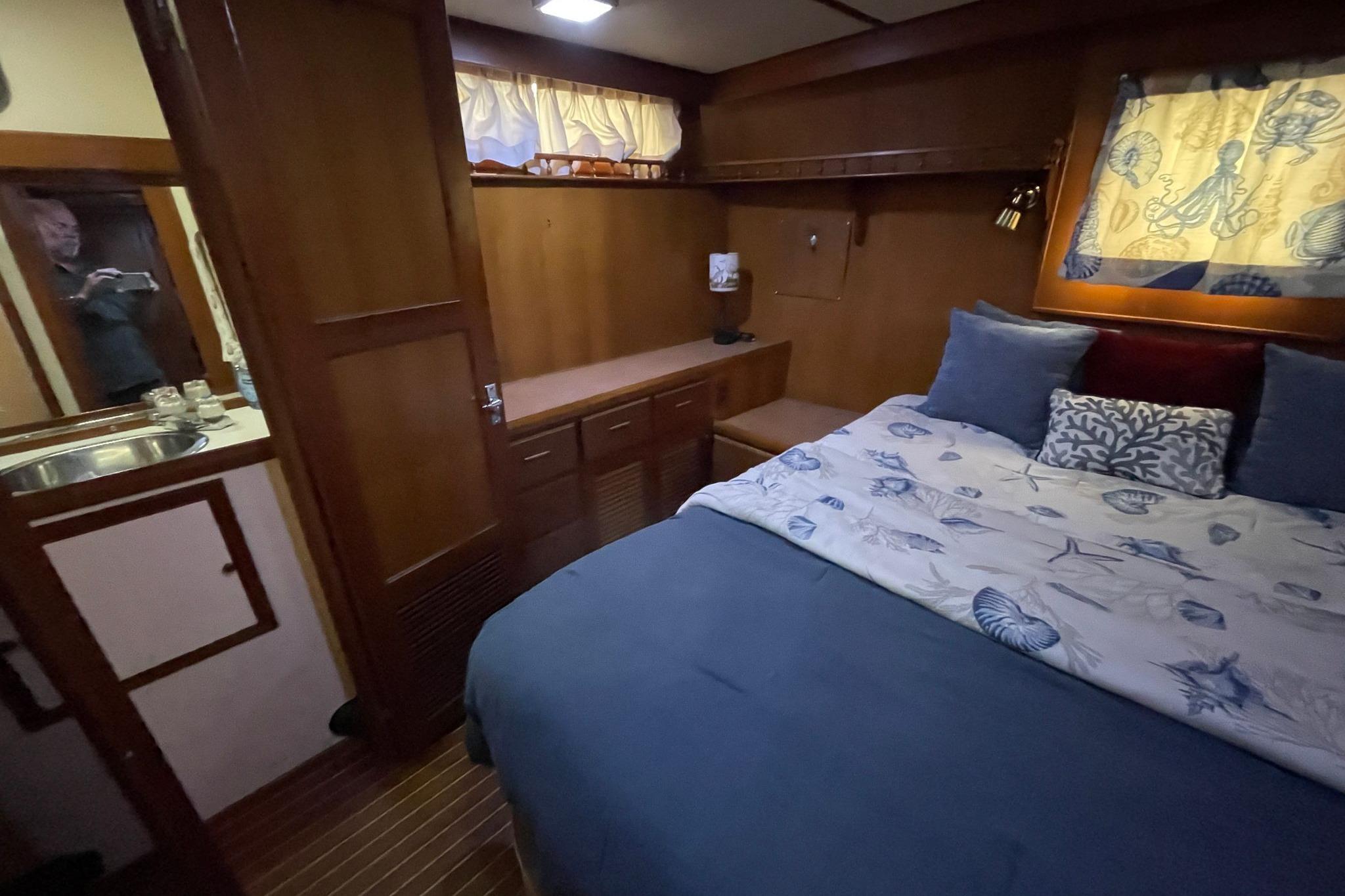Cozy interior of 1986 NOVA MARINE 36 Sundeck with bed, wooden cabinetry, and nautical decor.