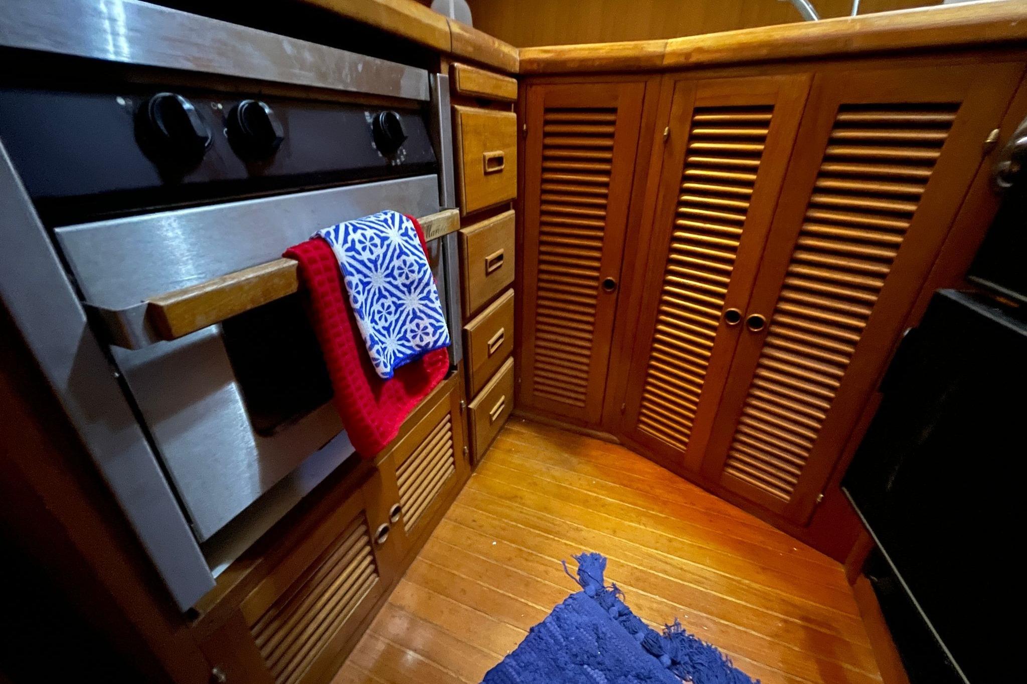 Galley kitchen in 1986 NOVA MARINE 36 Sundeck with wooden cabinets and stove.