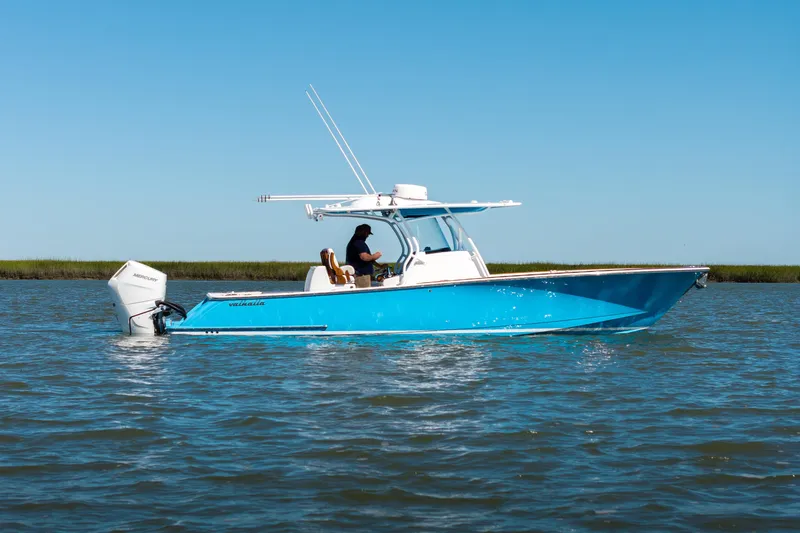 Sea Dawg Yacht Photos Pics 2024 Valhalla Boatworks V-33 in blue, cruising on calm waters under clear skies.