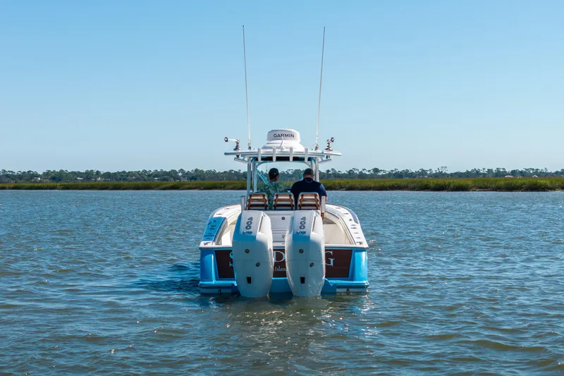 Sea Dawg Yacht Photos Pics 2024 Valhalla Boatworks V-33 cruising on calm waters, rear view.