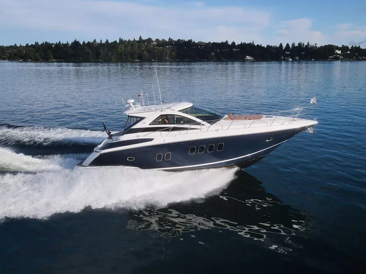 Blue Stiel Yacht Photos Pics 2009 Regal 52 Sport Coupe yacht cruising on a serene lake under a clear sky.