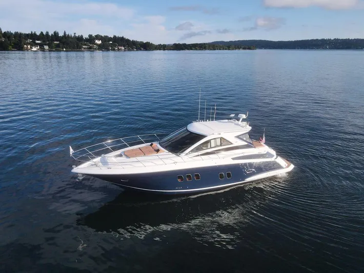 Blue Stiel Yacht Photos Pics 2009 Regal 52 Sport Coupe yacht cruising on a calm lake under a clear sky.