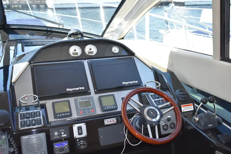 Blue Stiel Yacht Photos Pics Cockpit of 2009 Regal 52 Sport Coupe with Raymarine navigation system and wooden steering wheel.