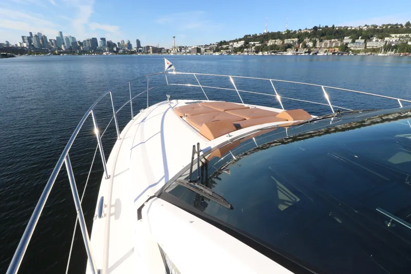 Blue Stiel Yacht Photos Pics 2009 Regal 52 Sport Coupe yacht cruising on a sunny day with city skyline in background.
