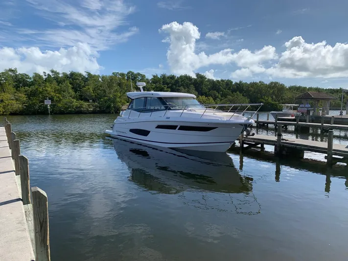 2021 Regal 38 Xo Yacht Photos Pics 2021 Regal 38 XO yacht docked on a serene lake under a blue sky.