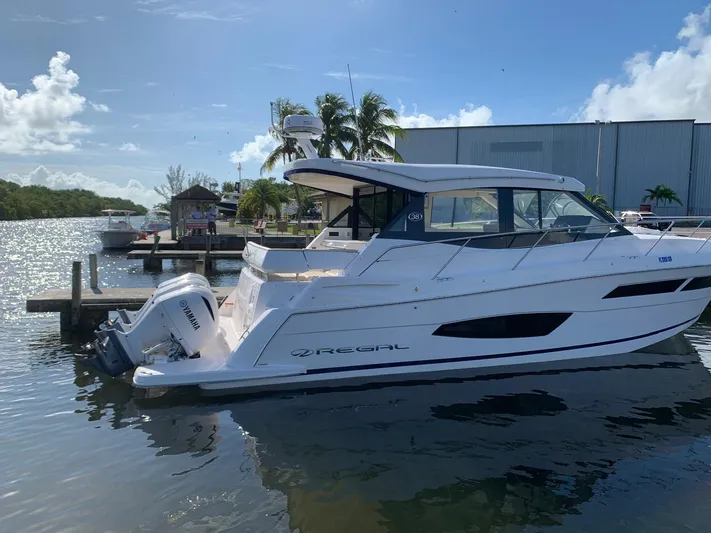 2021 Regal 38 Xo Yacht Photos Pics 2021 Regal 38 XO boat docked by palm trees under a clear blue sky.