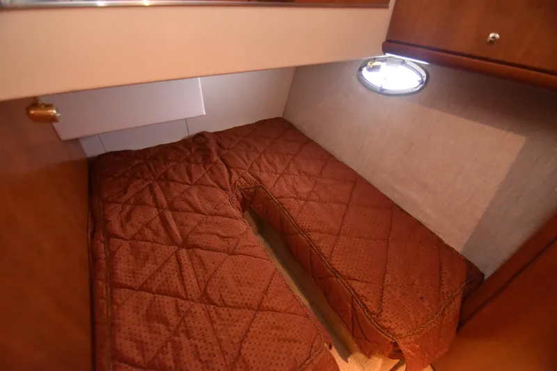 Sea Marie Yacht Photos Pics 2007 Silverton 38 Convertible cabin with brown quilted bedding and porthole window.
