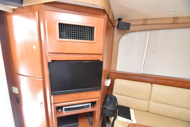 Sea Marie Yacht Photos Pics Interior of 2007 Silverton 38 Convertible yacht with TV, beige seating, and wooden cabinetry.