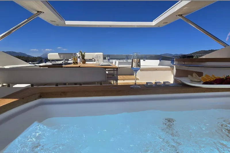 Red Rose Yacht Photos Pics Luxurious Aicon 85 yacht deck with jacuzzi, dining setup, and scenic ocean view.