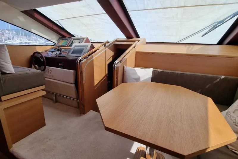 Red Rose Yacht Photos Pics Interior of 2010 Aicon 85 yacht with helm, seating, and wooden table.
