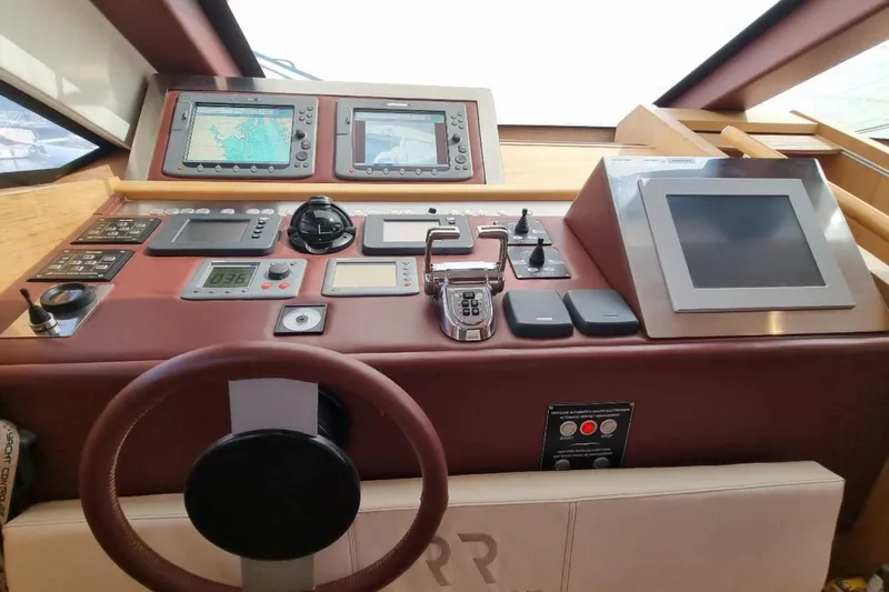 Red Rose Yacht Photos Pics Control panel of a 2010 Aicon 85 yacht with navigation screens and steering wheel.