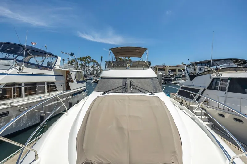 Shanti Yacht Photos Pics 2015 Prestige 500FB yacht docked between two boats under clear blue sky.