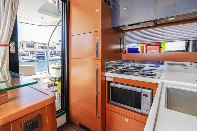 Shanti Yacht Photos Pics Modern kitchen interior on 2015 Prestige 500FB yacht, featuring appliances and marina view.