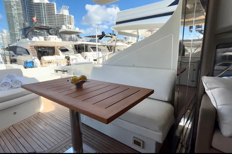 Boat Yacht Photos Pics Luxurious Azimut 68S yacht deck with wooden table, docked in a marina.