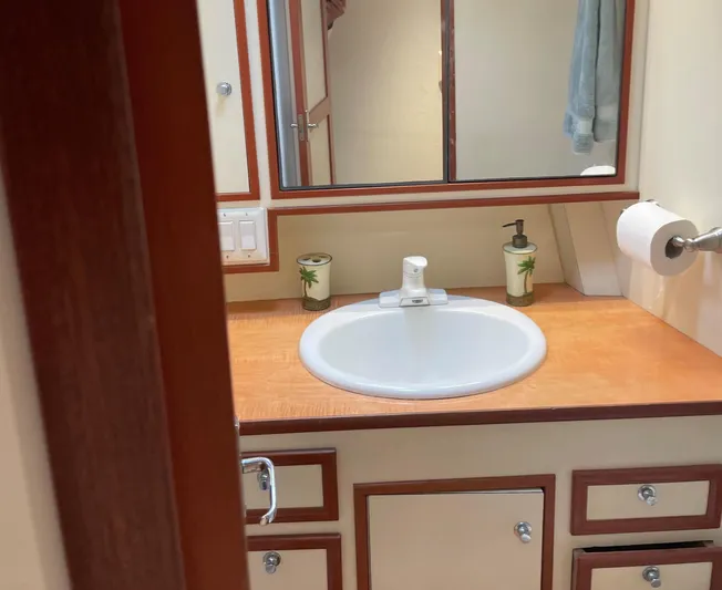 Red Witch Yacht Photos Pics Bathroom vanity in 2001 Custom Carolina Lydia 57 Sportfish, featuring sink and wooden cabinetry.