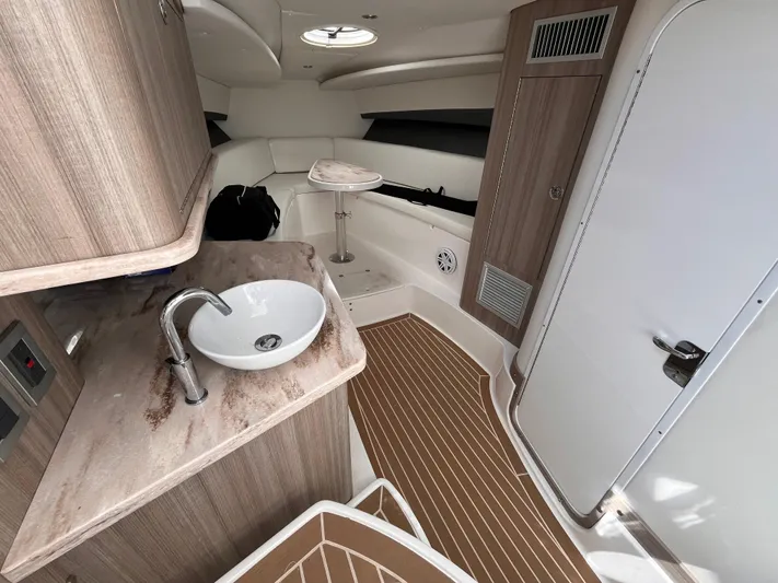  Yacht Photos Pics 2021 Fountain 38 SFC cabin interior with sink, seating, and wooden flooring.