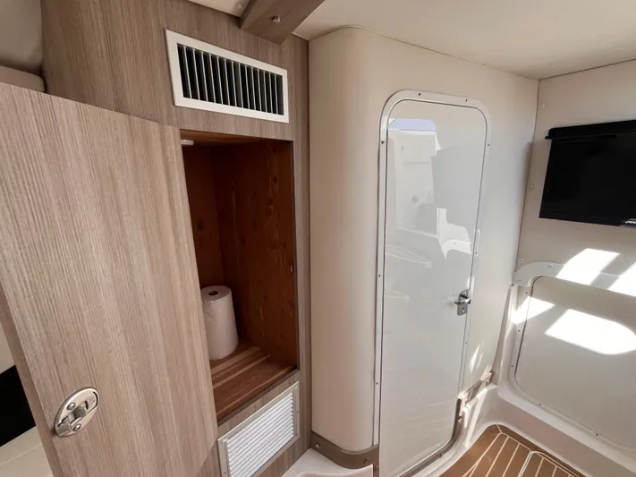  Yacht Photos Pics 2021 Fountain 38 SFC interior with wooden cabinetry, door, and wall-mounted TV.