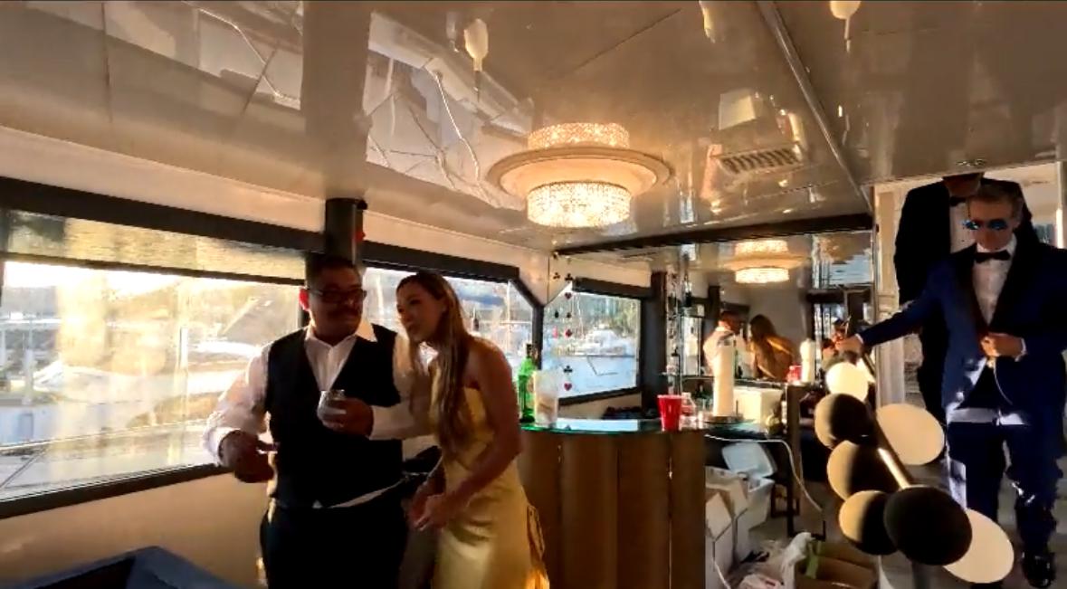 Luxurious yacht interior with elegant guests, chandeliers, and a festive atmosphere, 1989 custom model.