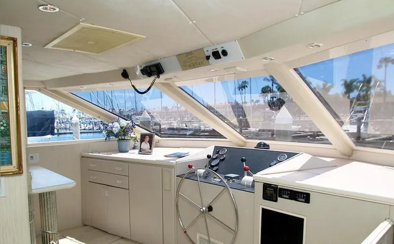 Scherzo Yacht Photos Pics Luxurious yacht interior with steering wheel, panoramic windows, and marina view, 1989 custom model.