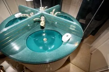 Scherzo Yacht Photos Pics Teal bathroom sink with gold faucet, mirrored backsplash, and soap dish, custom design from 1989.