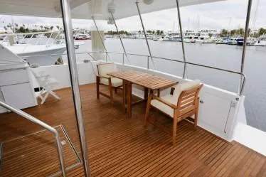 Scherzo Yacht Photos Pics Spacious yacht deck with wooden furniture, overlooking marina. Custom model, 1989.