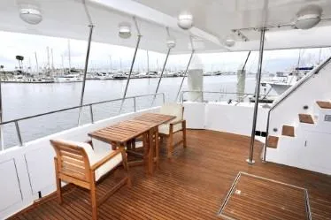 Scherzo Yacht Photos Pics Spacious yacht deck with wooden furniture, overlooking marina, Custom model, 1989.