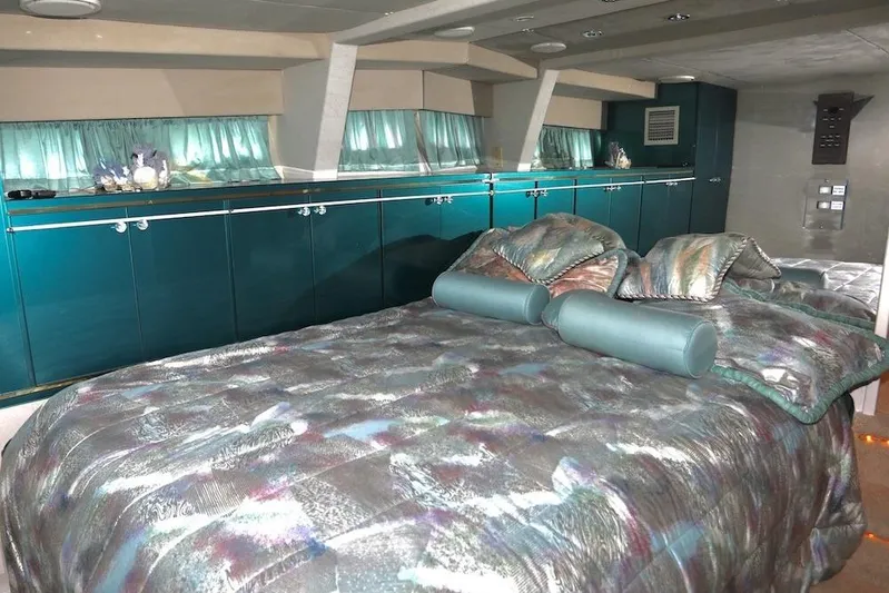 Scherzo Yacht Photos Pics Luxurious custom bedroom interior with teal accents and patterned bedding, 1989 design.